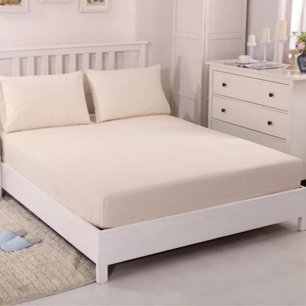 Earthing sheet in beige color installed on bed in bedroom.