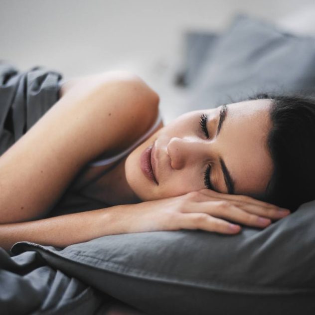 Grey colored grounding sheet with lady sleeping in bed.