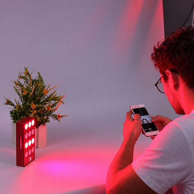 Man using a portable mini red light therapy panel at home.