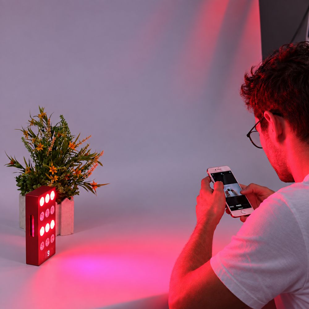 Man using a portable mini red light therapy panel at home. Man using a portable mini red light therapy panel at home.