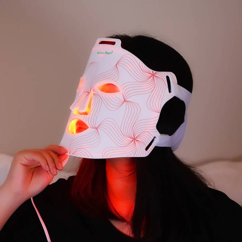 Side view of red light therapy LED face mask emitting red and near-infrared light for skin rejuvenation.