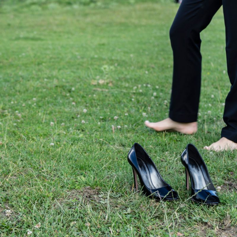 Girl in park, removed her shoes to ground her body. 