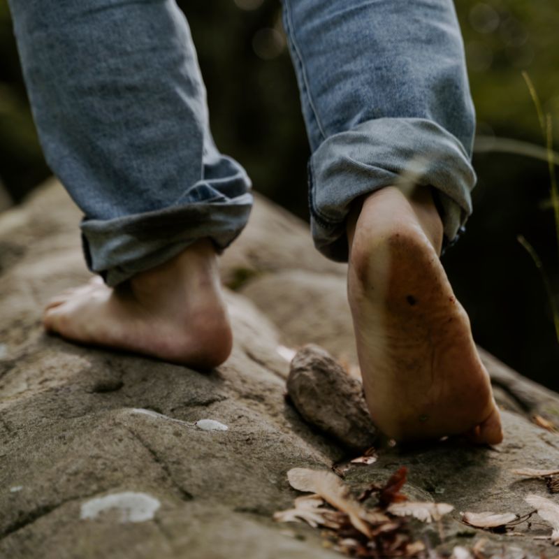 Person grounding their body without shoes outdoors in nature.