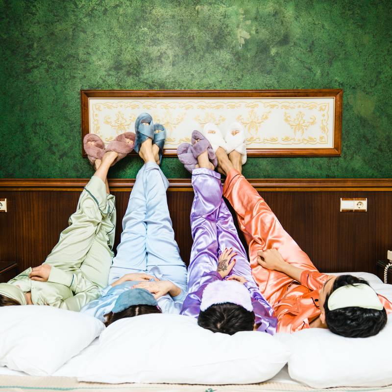 Friends in pjs laying on grounding and earthing sheet.