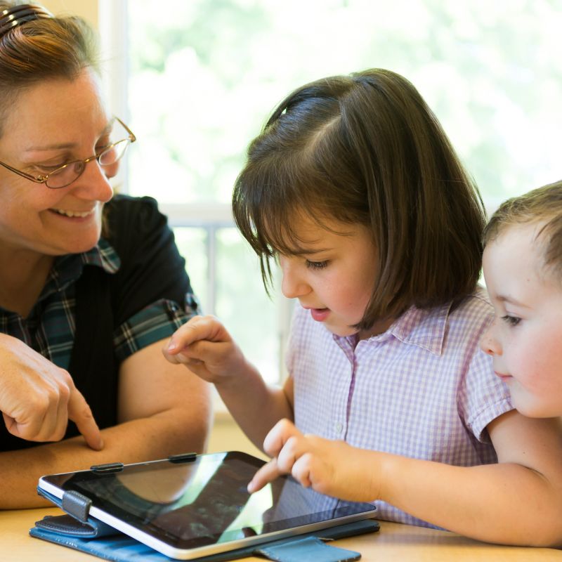 Young family teaching kids about the ipad.