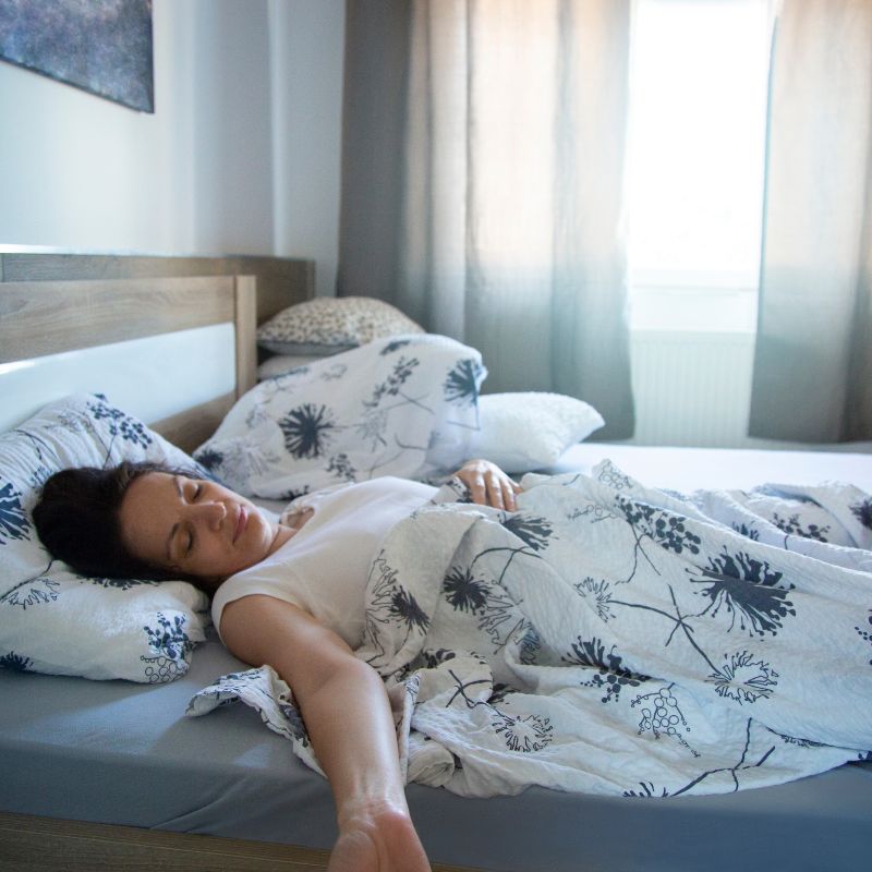 Young girl on grounding sheet, sleeping.