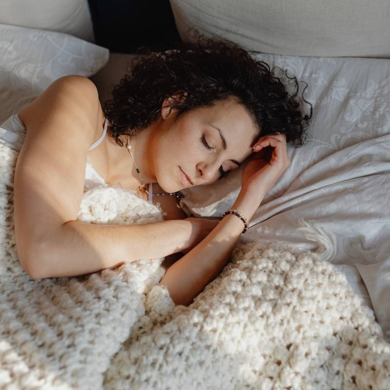 Lady sleeping on a grounding sheet.