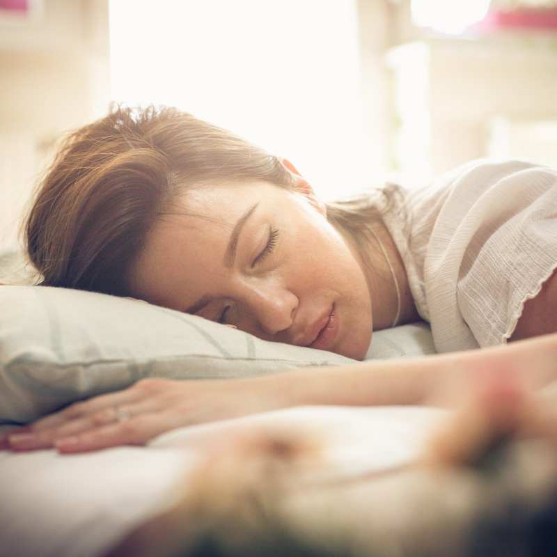 Woman sleeping peacefully on grounding sheet for better rest