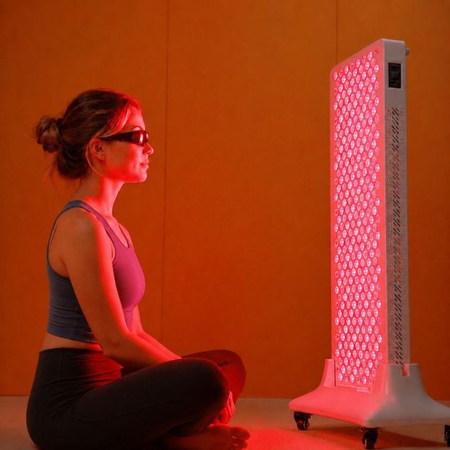 Woman using the ProX 1500 red light therapy panel at home for full body wellness
